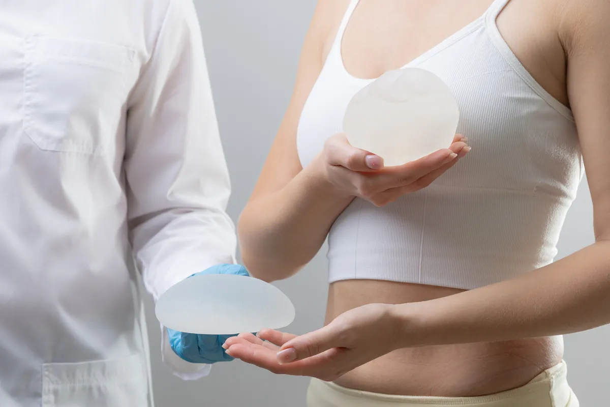 Woman comparing breast implant samples with a doctor