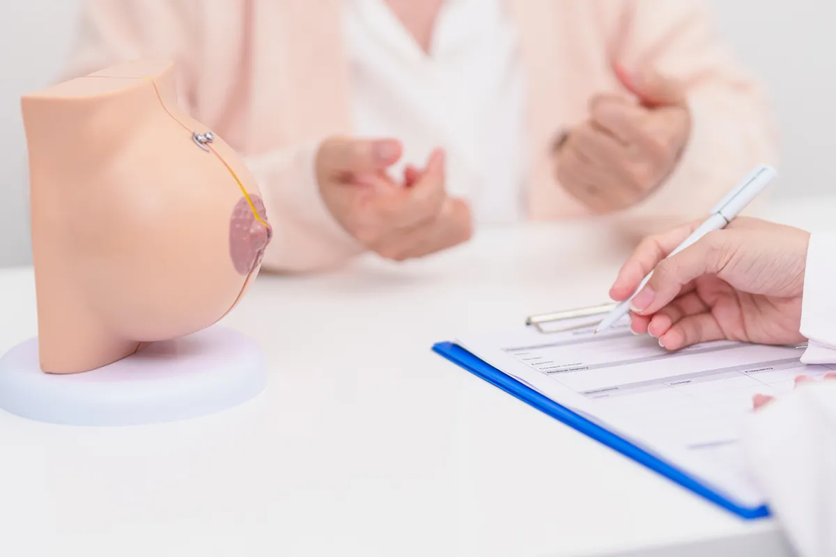 Surgeon and patient discussing implant options using a breast model